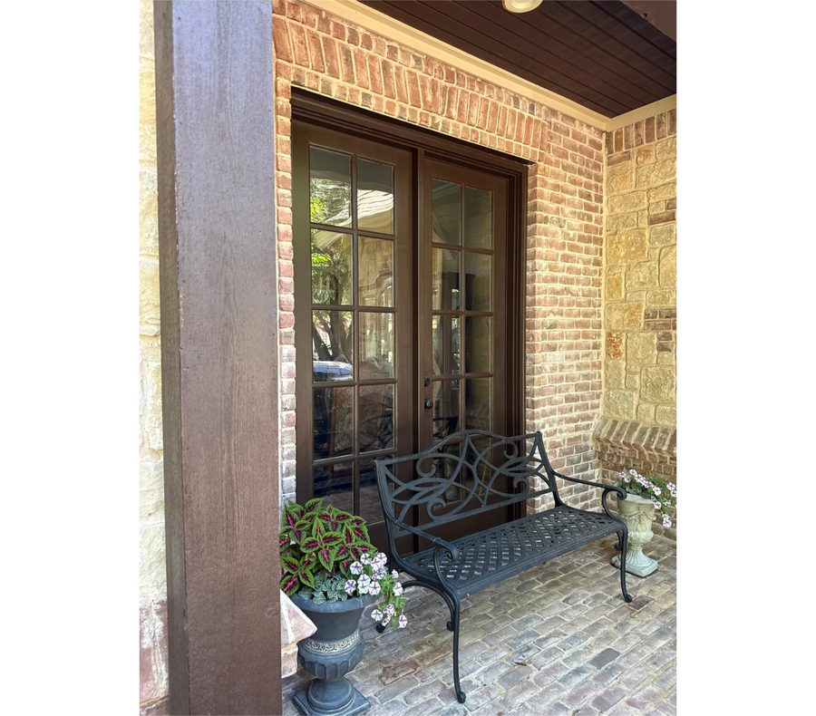 Clean glass French doors on a brick and stone front porch