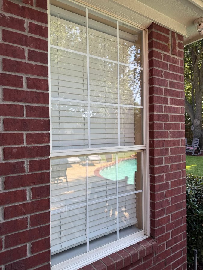 Grid-paned window on red brick with crystal-clear lower panes